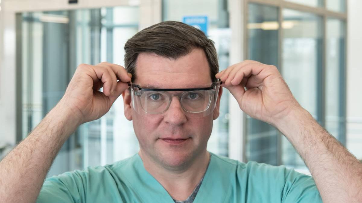 Ein Mitarbeiter des Uniklinikums Erlangen probiert eine Schutzbrille.