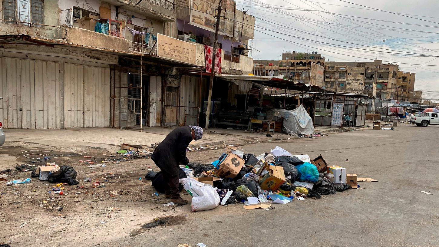 Ein Mann durchsucht einen Müllhaufen am Rande eines fast leeren Marktes. Hilfsorganisationen warnen vor einer starken Zunahme von Armut infolge des Coronavirus.
