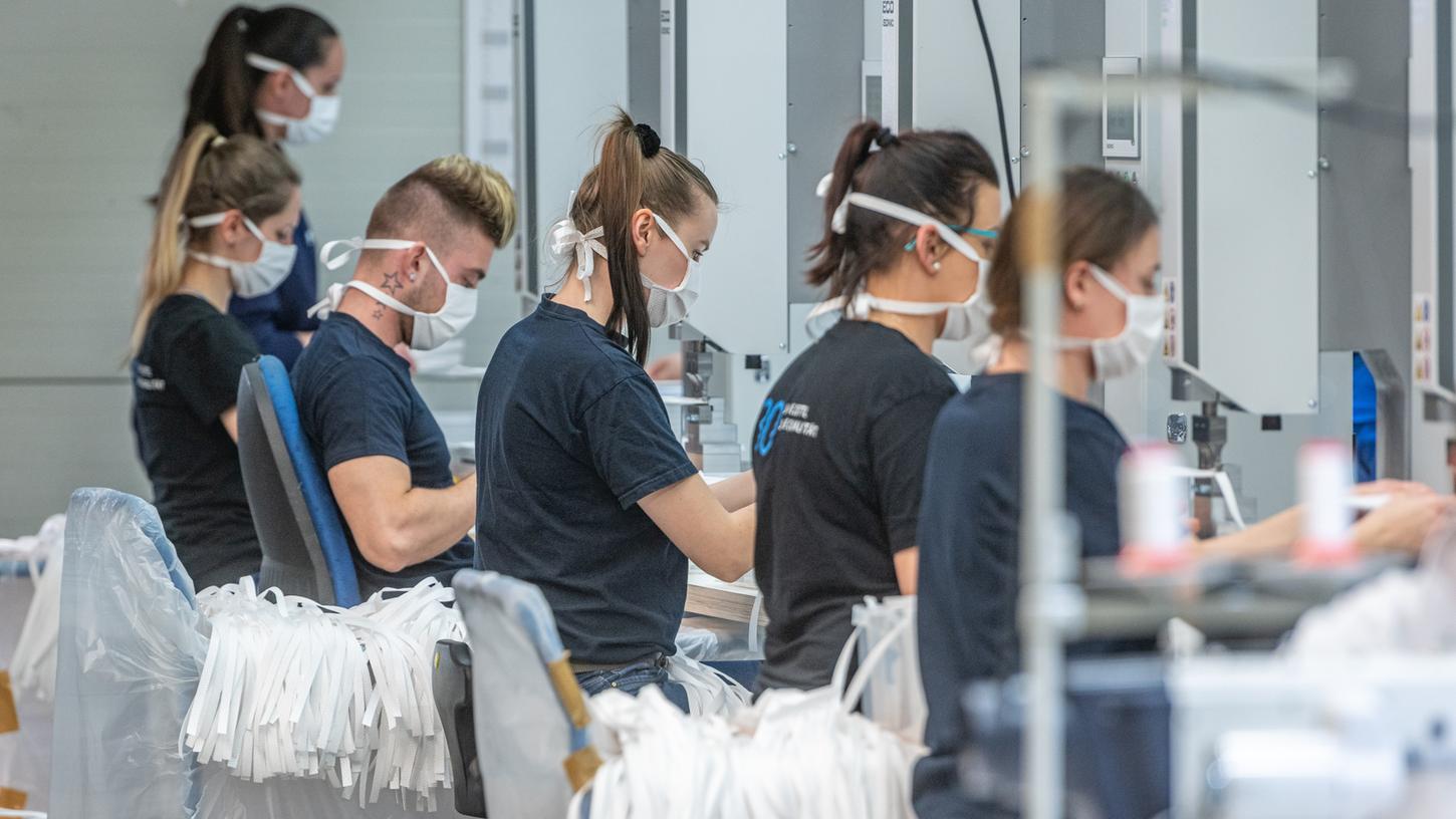 In der Corona-Krise versucht eine Vielzahl bayerischer Unternehmen mit Produkten jenseits ihrer eigentlichen Expertise zu helfen. Mitarbeiter des Automobilzulieferers Zettl produzieren Mundschutzmasken.