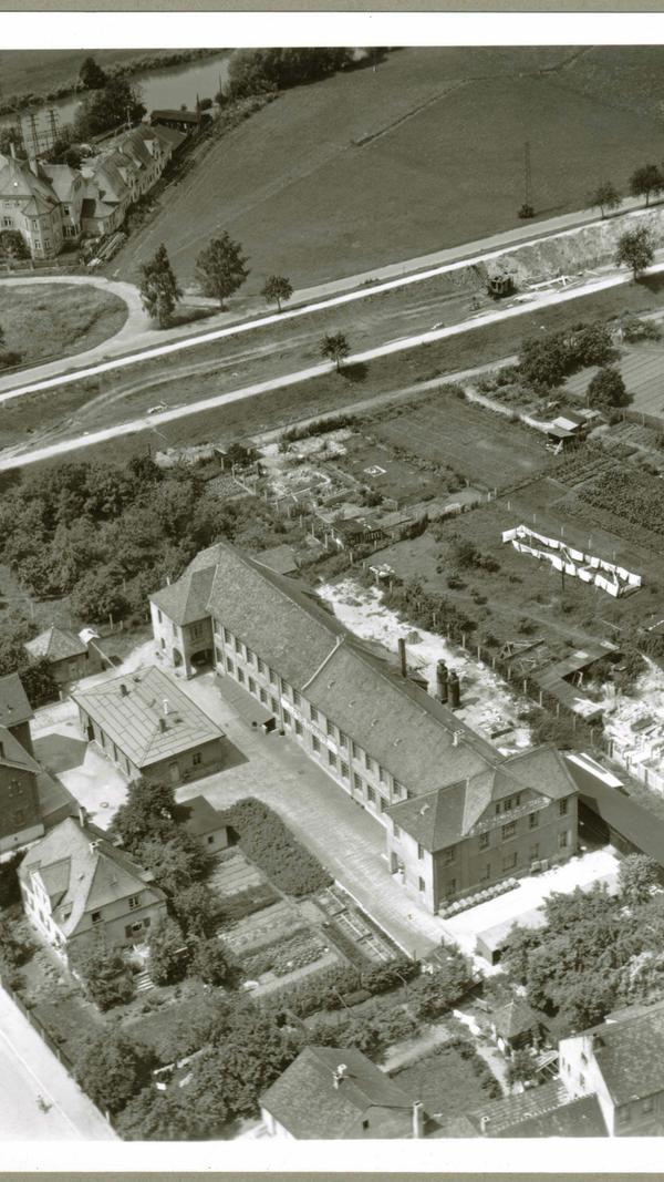 Nachdem die Amerikaner am Vortag zur Zermürbung der Moral mit der ziellosen Beschie-ßung der Stadt begonnen hatten, stellten sie am 16. April, einem Montag, ein Ultimatum bis 11 Uhr. In letzter Minute traf der Kampfkommandant, Oberstleutnant Werner Lorleberg, zusammen mit Oberbürgermeister Dr. Herbert Ohly und Polizeioberleutnant Andreas Fischer, der die weiße Fahne trug, am von den Siegern bestimmten Treffpunkt Spardorfer Straße 19 ein, wo etwa um 11.30 Uhr die Übergabe stattfand. Da eine „Kampfgruppe“ in der Thalermühle (auf dem Foto im Hintergrund) - hier eine Luftaufnahme - nicht kapitulieren wollte, stellten die Amerikaner ein zweites Ultimatum bis 14 Uhr.
