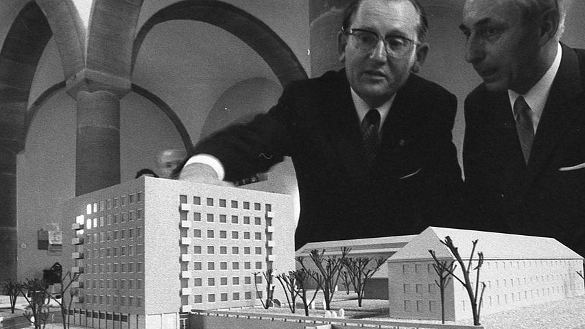Minister Dr. Pirkl (links) lässt sich von Regierungsbaudirektor Max Spannagl das Modell erklären. Rechts die Altbauten. Dem Hochhaus schließt sich ein Flachbau an. Hier geht es zum Artikel vom 21. April 1970: Viel Hilfe unter einem Dach