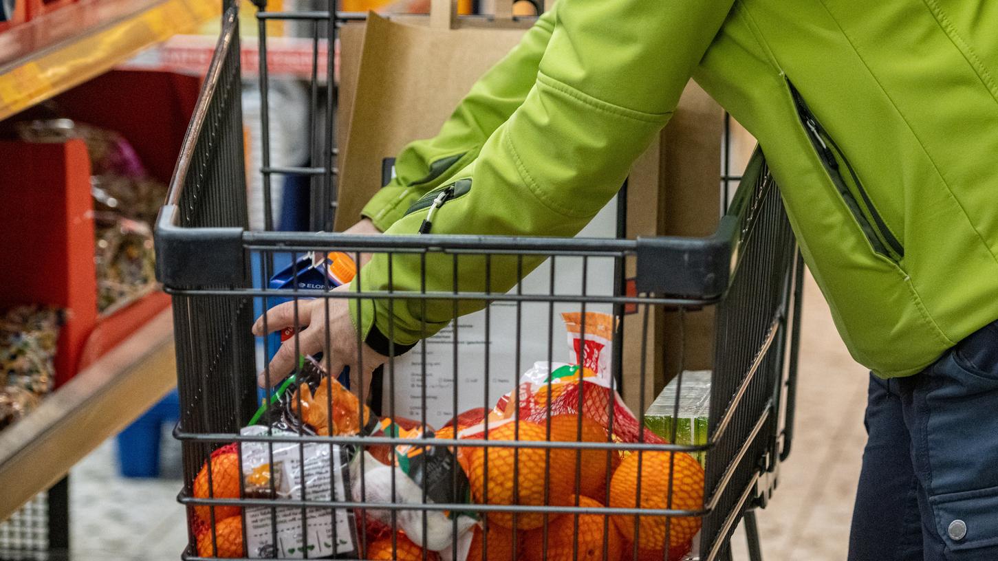 Eine Frau legt in einem Supermarkt Lebensmittel in einen Einkaufswagen. Ehrenamtlich Hilfe erfahren Mitglieder der Corona-Risikogruppe auch im Landkreis Neumarkt.