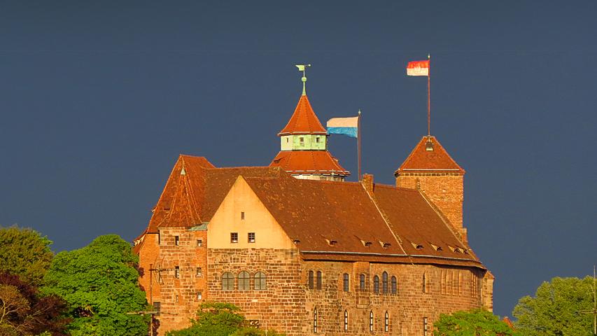 Angestrahlt von der untergehenden Sonne trotzt die Nürnberger Burg dem anrückenden Gewitter.