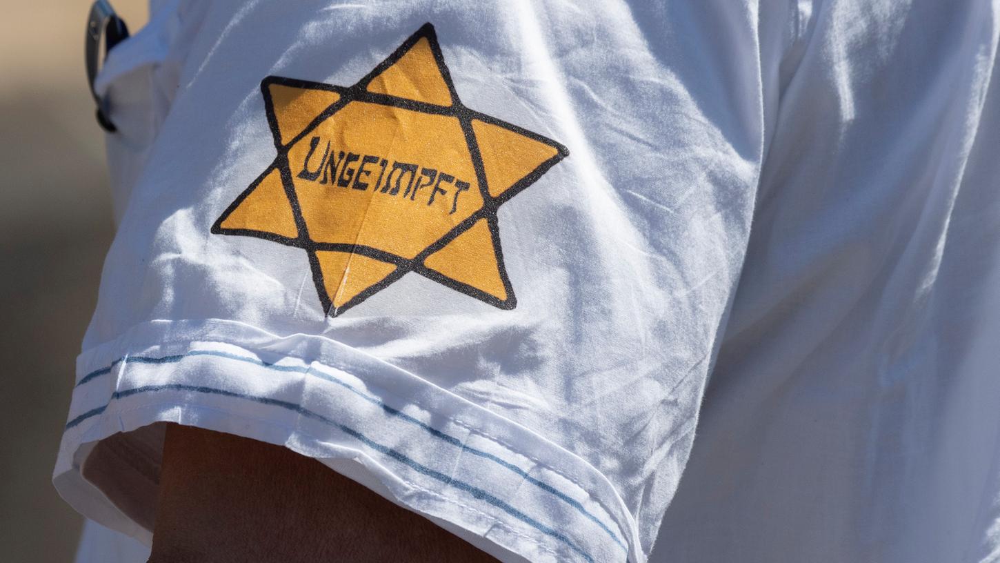 "Ungeimpft" steht auf einem nachgebildeten Judenstern am Arm eines Mannes, der versucht hatte, sich unter die Teilnehmer einer Demonstration zu mischen