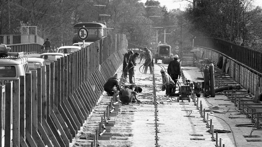 Unser Bild unten veranschaulicht, wie die westliche Hälfte der Brücke abgetragen wird. Die eisernen Querspanngliedern werden durchschnitten und dann neu gebunden, damit der Verkehr auf der Ostseite weiter rollen kann. Hier geht es zum Artikel vom 22. Mai 1970: Sand im Getriebe.
