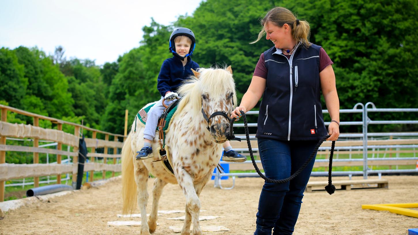 Der sechsjährige Korbinian freut sich, wieder mit Pony Merlin "arbeiten" zu dürfen. Hilfestellung – mit entsprechendem Abstand – bekommt er von Reitlehrerin Esther Köhler-Manger.