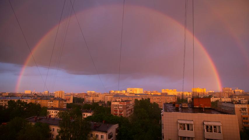 Der Regenbogen ist nicht nur ein Symbol für die Verbindung zwischen Himmel und Erde sondern steht auch für Harmonie. In dieser Szene aus Moskau, die Wohngebäude am Rande der russischen Metropole zeigen, wirkt das Naturschauspiel wie ein Schutzschild. 