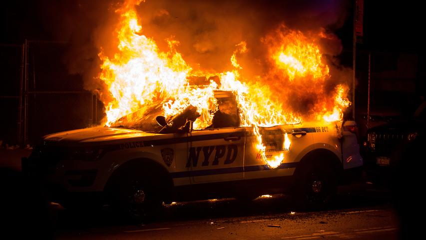 30.05.2020, USA, New York: Ein Geländewagen der New Yorker Polizei steht während der Proteste in der Stadt im New Yorker Stadtbezirk Brooklyn in Flammen. Der Protest richtet sich nach dem gewaltsamen Tod des Afroamerikaners Floyd durch einen weißen Polizisten gegen Rassismus und Polizeigewalt. Die teils schweren Ausschreitungen in verschiedenen US-Metropolen dauern seit mehreren Tagen an. Foto: Michael Nagle/XinHua/dpa +++ dpa-Bildfunk +++
