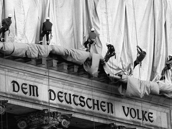 1995 rollten Gewerbekletterer die Verhüllungsplanen für den Berliner Reichstag vom Giebel des Bauwerks ab.