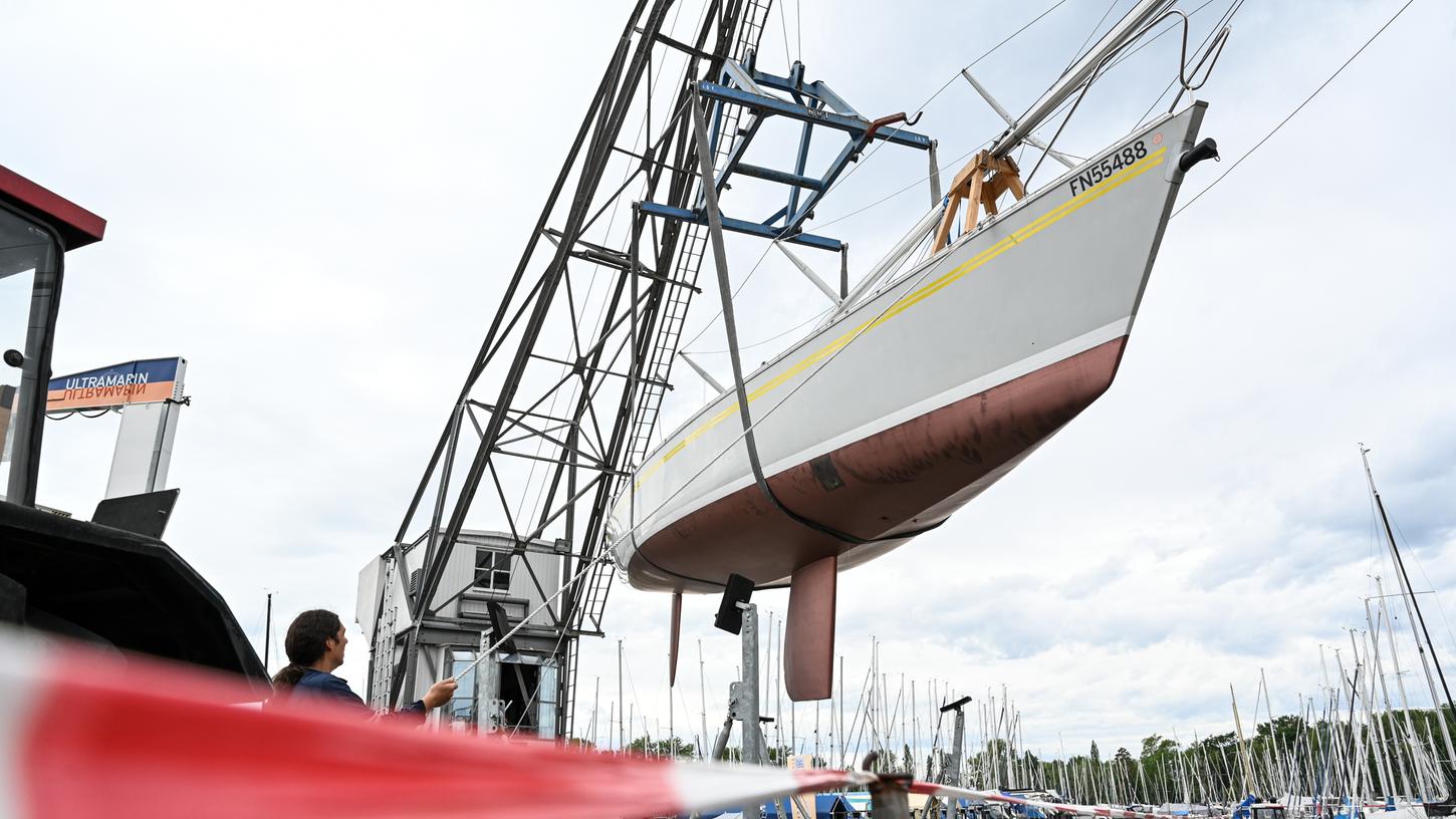 Ein Kran hievt eine Segelyacht ins Hafenbecken von Gohren am Bodensee. Nicht weit davon entfernt wollte ein Mann sein Motorboot über eine Slipanlage ins Wasser lassen und versenkte dabei sein Auto gleich mit.