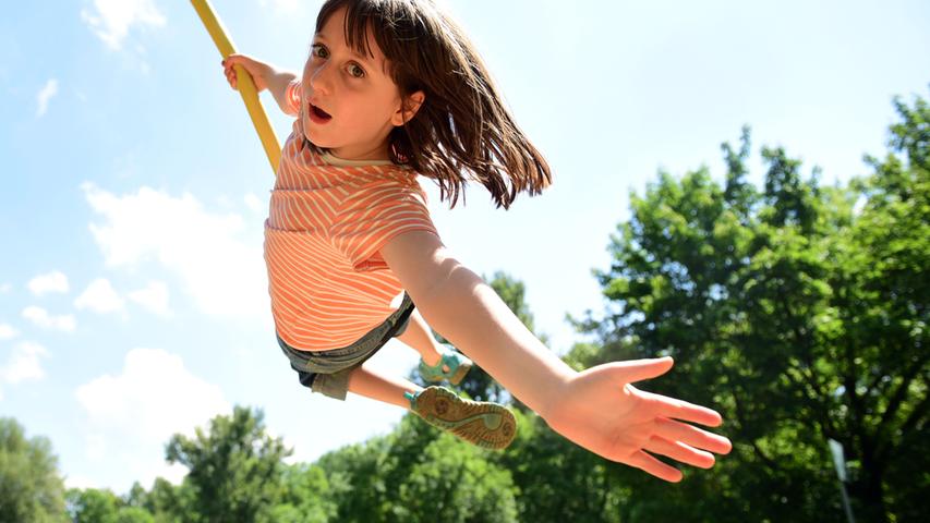 Viele Fürtherinnen und Fürther nutzen das hochsommerliche Wetter, um draußen zu spielen und zu toben oder einfach nur um Freunde zu treffen und zu entspannen - so wie die zehnjährige Annika im Stadtpark.