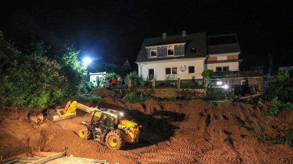 Um das Grundstück vor dem Abrutschen zu schützen, wird Material in die Baugrube und an den Hang geschüttet.