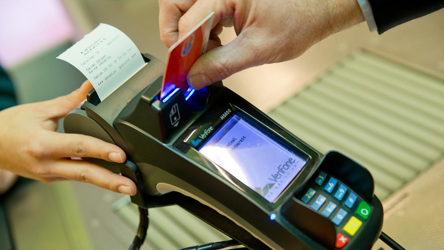 Ein Kunde zahlt in einem Supermarkt mit einer EC-Karte an der Kasse.