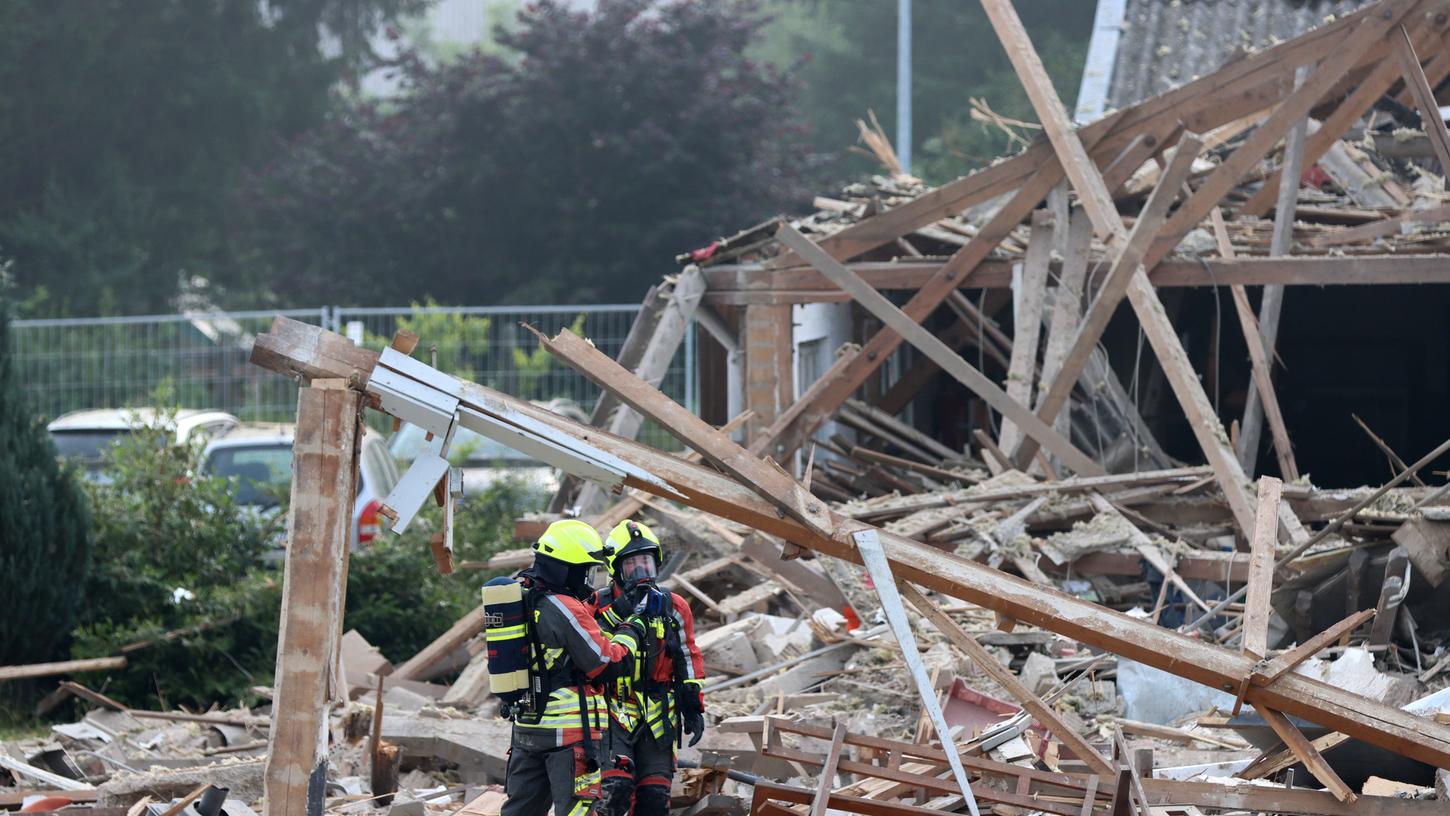 Feuerwehrleute stehen in den Trümmern der Halle in Günzburg, die in der Nähe des Bahnhofs am Mittwochmorgen explodiert ist.