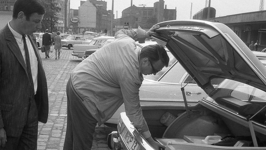 Ein Kripobeamter demonstriert an einem geparkten Pkw beim Bauhof, wie leicht man durch ein Ausstellfenster Beute herausangelt. Hier geht es zum Kalenderblatt vom 18. Juni 1970: Kripo als Autodiebe