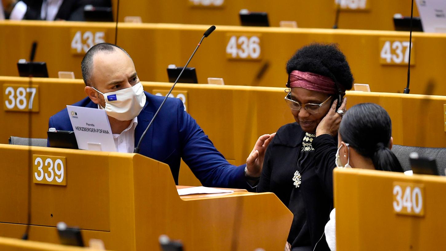 Abgeordnete der Grünen sitzen neben der Erlanger Politikerin Pierrette Herzberger-Fofana, nachdem diese im EU-Parlament geschildert hat, was ihr am Brüssler Nordbahnhof widerfahren war.
