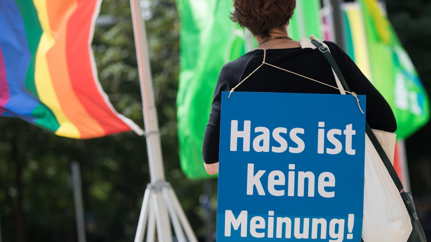 Eine Aktivistin der Nichtregierungsorganisation Campact protestiert mit einem Plakat mit der Aufschrift "Hass ist keine Meinung" gegen Hassnachrichten im Internet. Künftig wird gegen solche entschiedener vorgegangen.