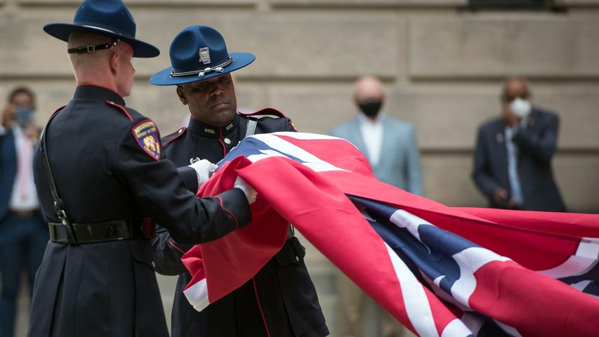 Mitglieder der Missisippi Highway Safety Patrol Honor Guard rollen die bisherige Flagge ihres Bundesstaats zusammen. Als letzter US-Bundesstaat entfernt Mississippi die Kriegsflagge der Südstaaten aus seiner Fahne. Das als rassistisch angesehene Symbol steht seit Jahren in der Kritik.