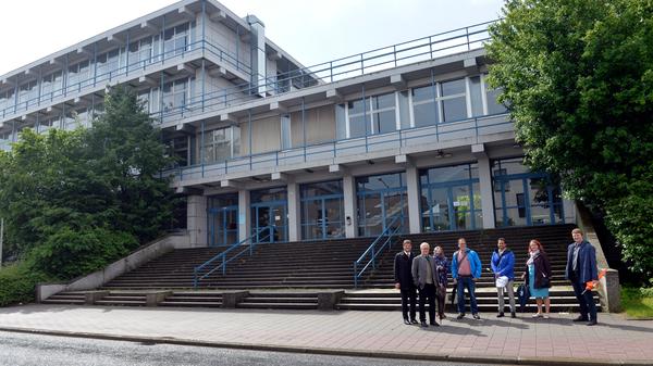 Das große Hörsaalgebäude an der Erlanger Henkestraße wird abgerissen und an gleicher Stelle ebenfalls bis zum Jahr 2026 ein Neubau für 83,5 Millionen Euro entstehen. Als vorübergehenden Ersatz bekommt die Uni auf dem Südgelände für 17 Millionen Euro zwei Hörsaalgebäude in schneller Holzbauweise errichtet, die anschließend die Technische und Naturwissenschaftliche Fakultät erweitern sollen. Hier im Bild: Das Gebäude der Alten Chemie an der Henkestraße, davor (v.l.) Uni-Präsident Joachim Hornegger, Uni-Kanzler Christian Zens und Erlangens Oberbürgermeister Florian Janik.