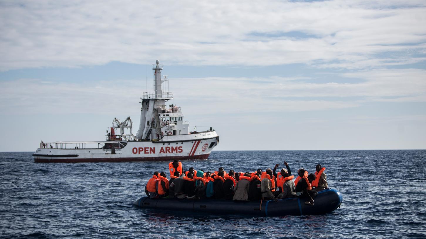 Flüchtlinge, die auf einem Schlauchboot im Mittelmeer treiben, freuen sich über die Ankunft eines Schiffes der spanischen Nichtregierungsorganisation Pro Activa Open Arms (Archiv).
Flüchtlinge, die auf einem Schlauchboot im Mittelmeer treiben, freuen sich über die Ankunft eines Schiffes der spanischen Nichtregierungsorganisation Pro Activa Open Arms (Archiv).
