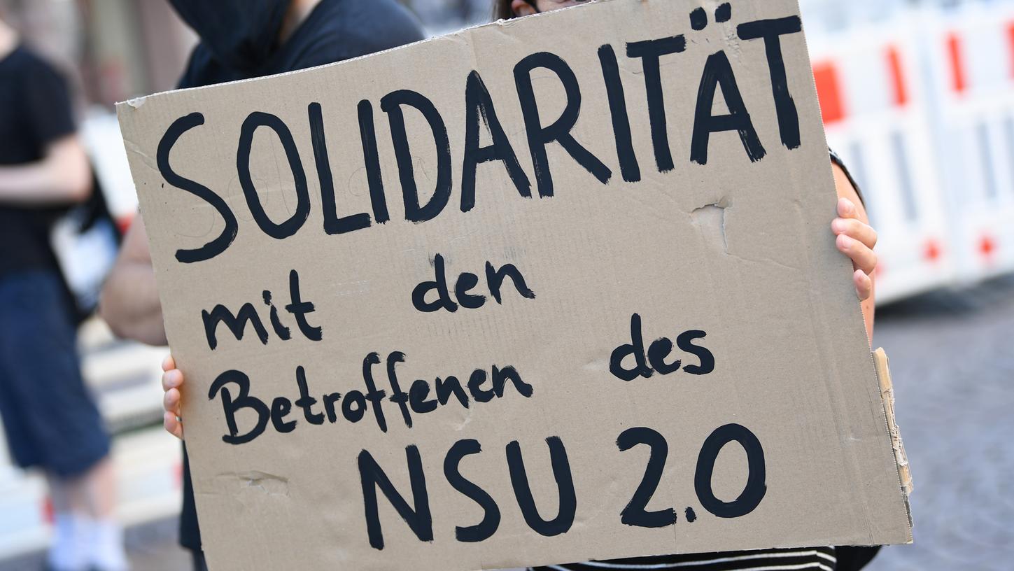 Ein Demonstrantin hält während einer Kundgebung in der Wiesbadener Innenstadt ein Plakat mit der Aufschrift "Solidarität mit den Betroffenen des NSU 2.0". Anlass der Protestaktion war eine Sitzung des Landtags-Innenausschusses zu der Affäre um rechtsextreme Drohschreiben. 