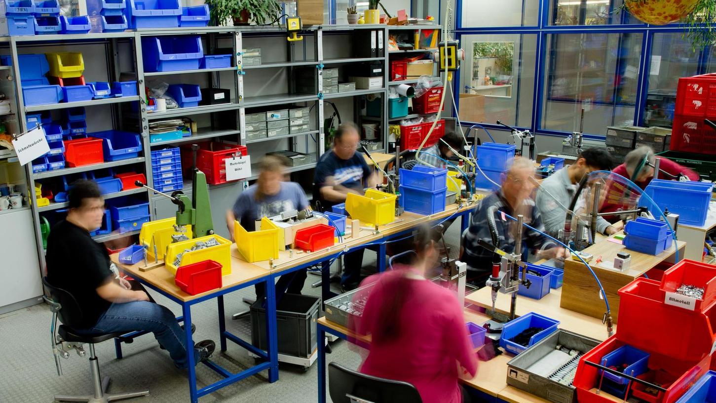 Menschen mit Behinderung arbeiten in einer Werkstatt. Auch solche Eingliederungshilfen gehören zu Zuständigkeit der sieben Bezirke in Bayern.