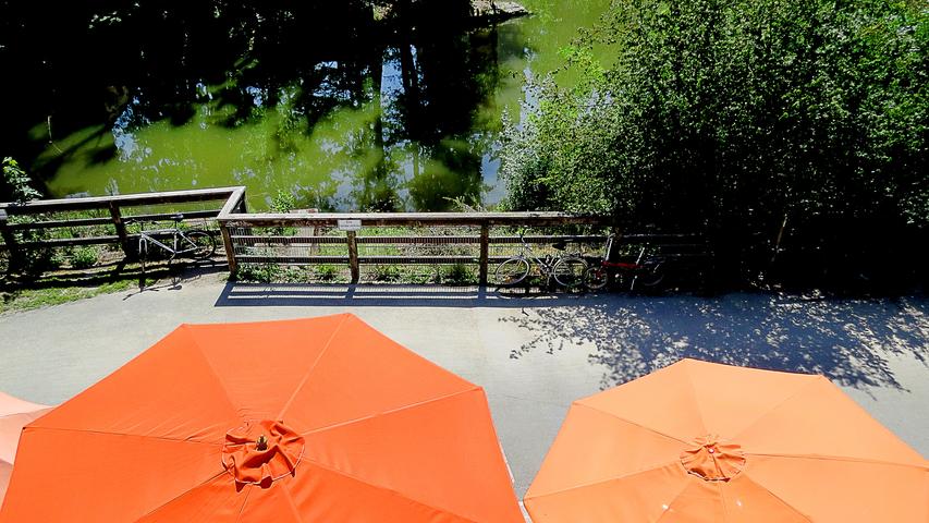 Gut beschirmt lässt es sich auch an sonnenheißen Tagen am Pegnitzufer aushalten. Blick von oben auf die farbig leuchtenden Sonnenschirme des "Schnepperschütz".