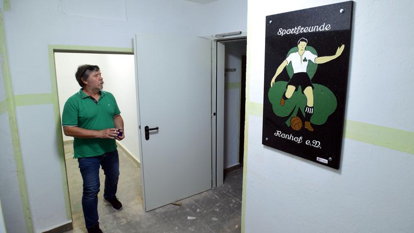 Dieter Wirth von den Sportfreunden Ronhof mit dem Logo, das bereits an der Wand hängt.