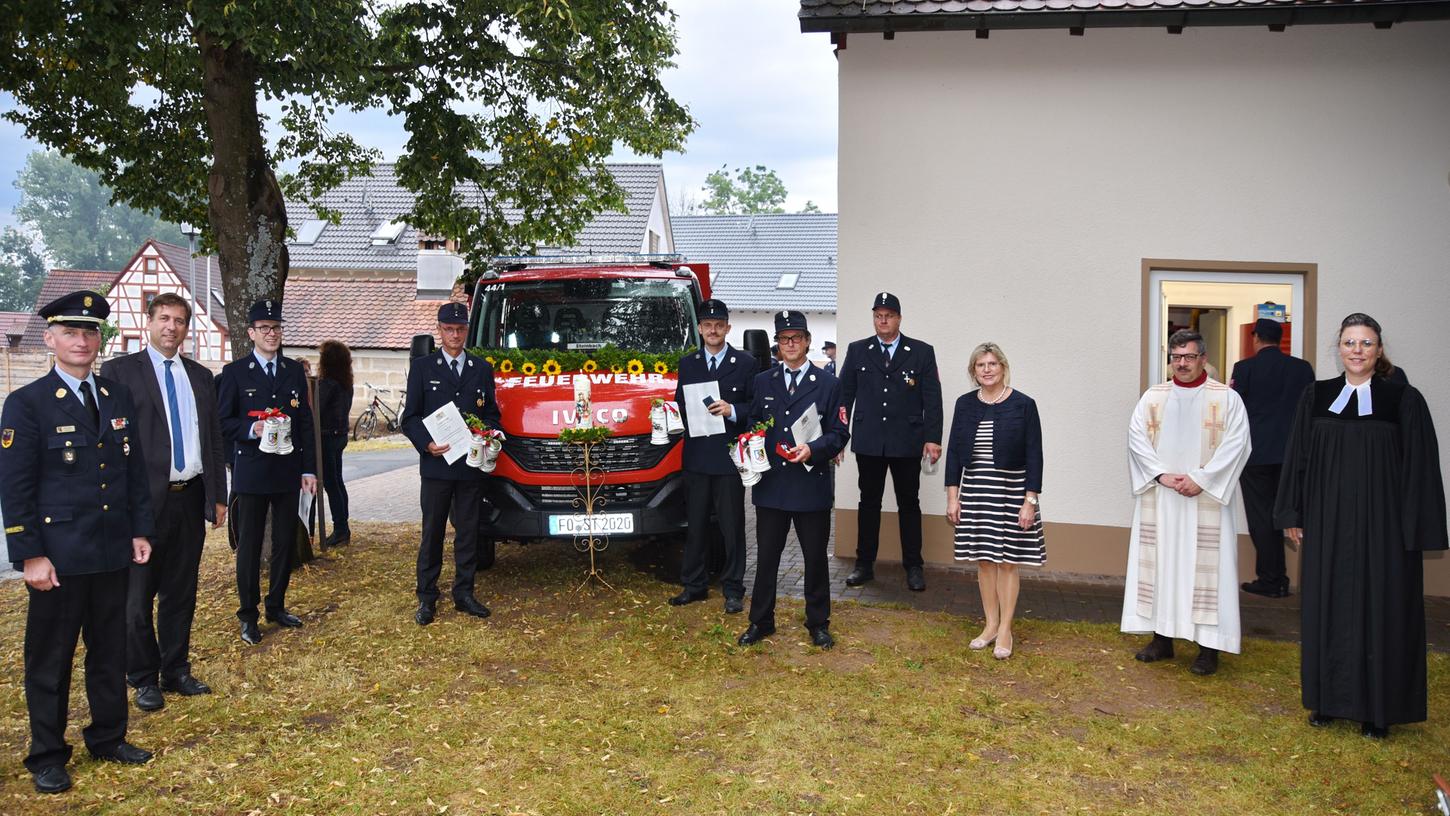 Das neue Auto sowie die Geehrten mit Kreisbrandrat Oliver Flake, Landrat Hermann Ulm, Bürgermeisterin Gertrud Werner sowie die kirchlichen Vertreter Pfarrerin Sabrina Kielon und Joachim Cibura.