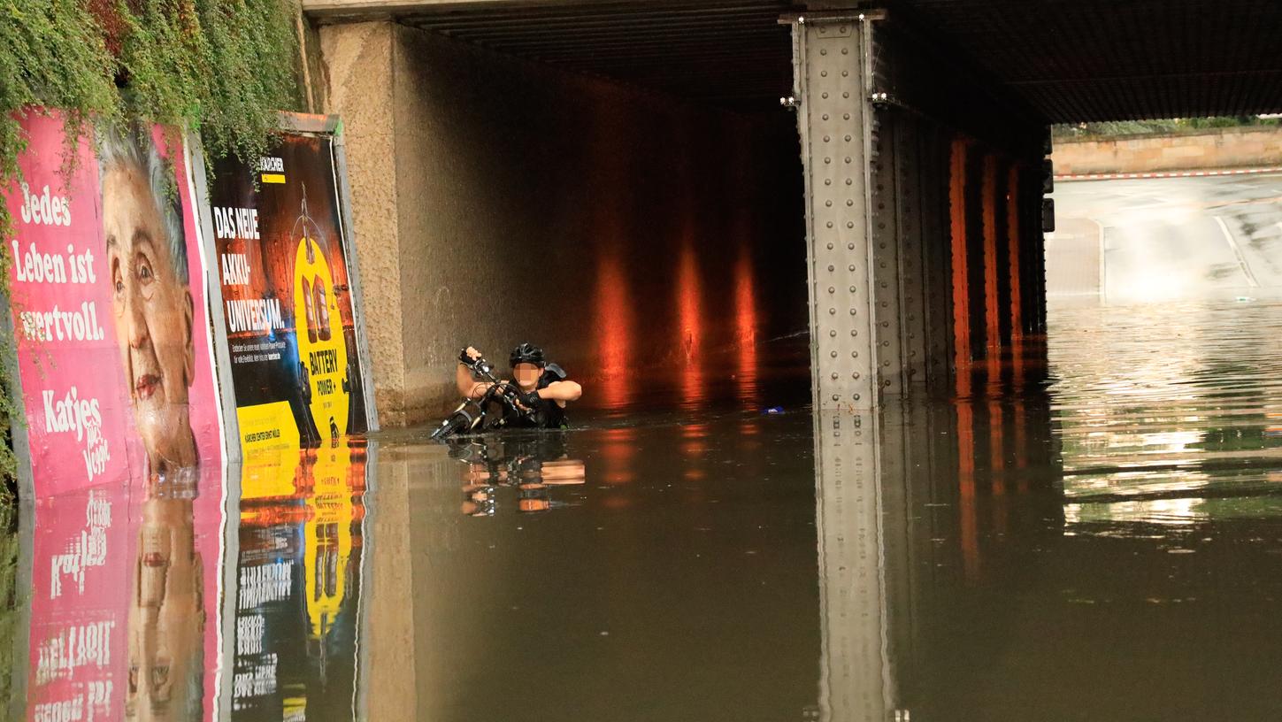 Eine Unterführung in Erlangen war so überschwemmt, dass das Wasser brusthoch reichte. Hier blieb auch ein Transporter hängen, dessen drei Insassen sich schwimmend ins Trockene retteten.
Eine Unterführung in Erlangen war so überschwemmt, dass das Wasser brusthoch reichte. Hier blieb auch ein Transporter hängen, dessen drei Insassen sich schwimmend ins Trockene retteten.
