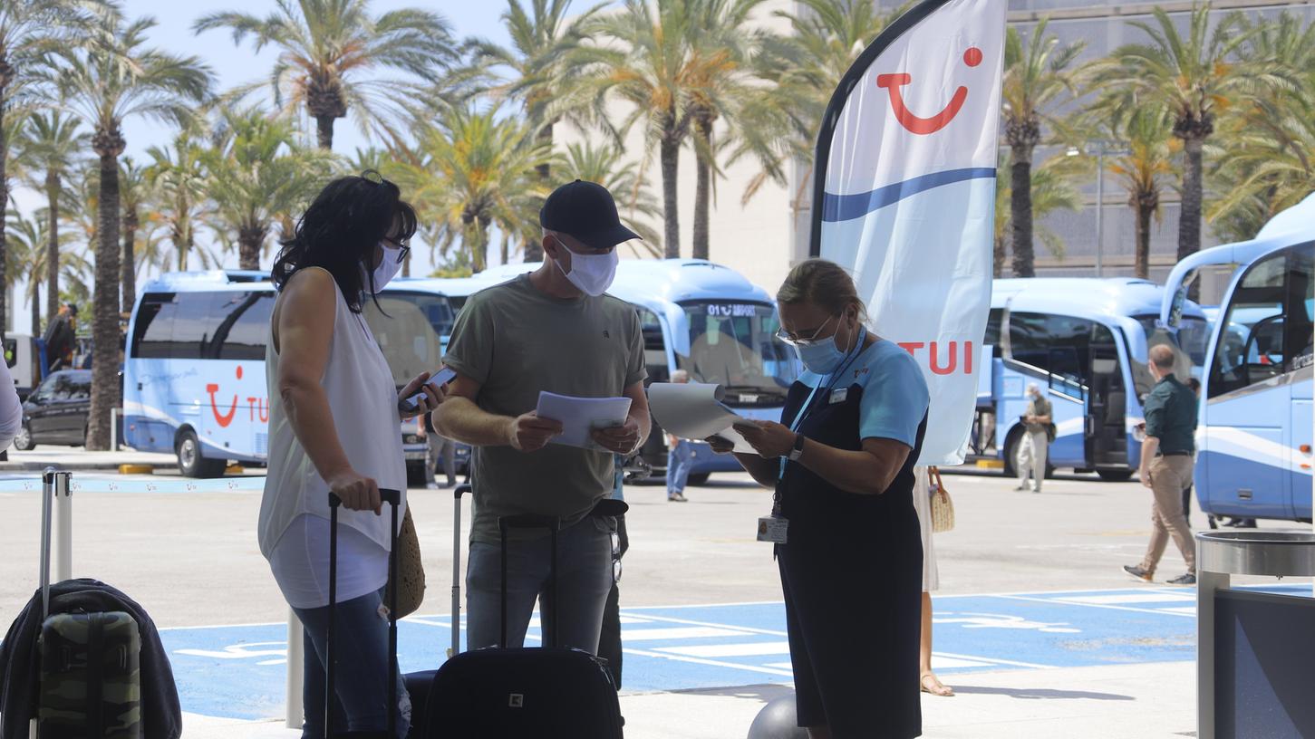 Eine Tui-Mitarbeiterin bietet neu angekommenen Passagieren auf dem Flughafen Palma de Mallorca Hilfe an.