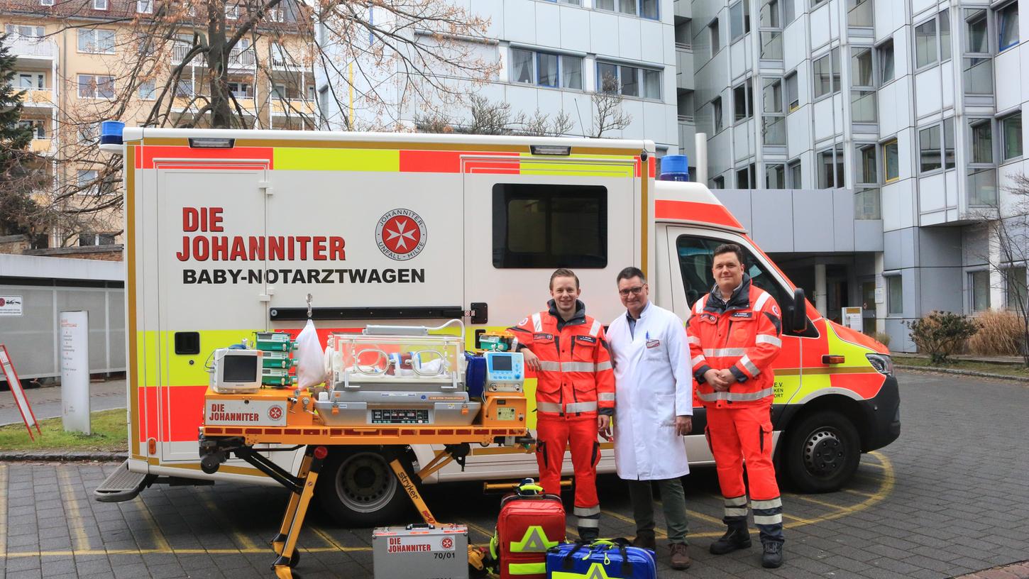 Die Notfallsanitäter der Johanniter mit Prof. Dr. Schroth, Chefarzt der Neonatologie der Cnopfschen Kinderklinik in Nürnberg vor dem Babynotarztwagen.