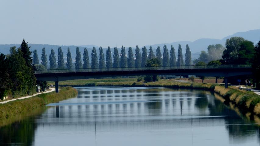 Eine Spiegelung am RMD-Kanal bei Erlangen: Wenn man das Spiegelbild genau anschaut, erkennt man statt Brücke und Bäumen einen Palast mit vielen Fenstern. 