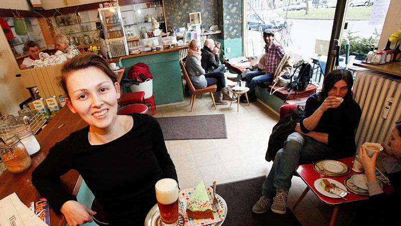 Nina Adler serviert im Café Regina ein Herrengedeck , ein kleines Bier und ein Stück Kuchen.