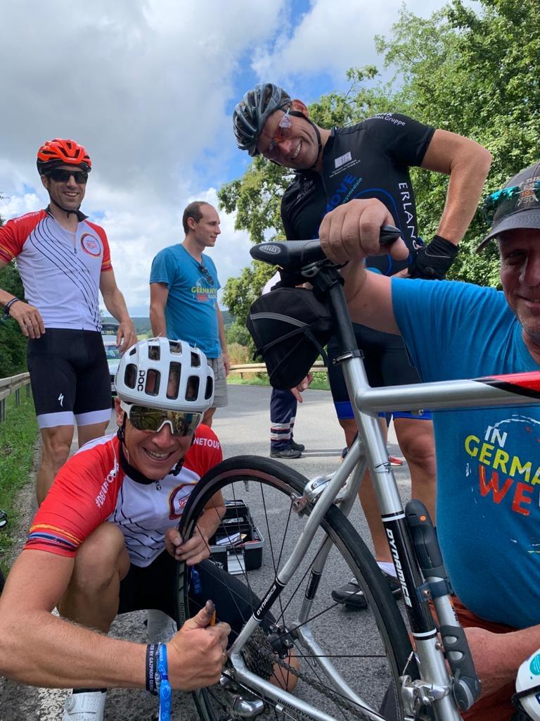 Am ersten längeren Anstieg musste Jörg Volleth (im Bild oben rechts) absteigen. Die Schaltung streikte. Im Radsport aber hilft man sich, und so reparierte der mehrfache Deutsche Meister Fabian Wegmann (unten links) direkt am Hang das Fahrrad des Erlanger Bürgermeisters.