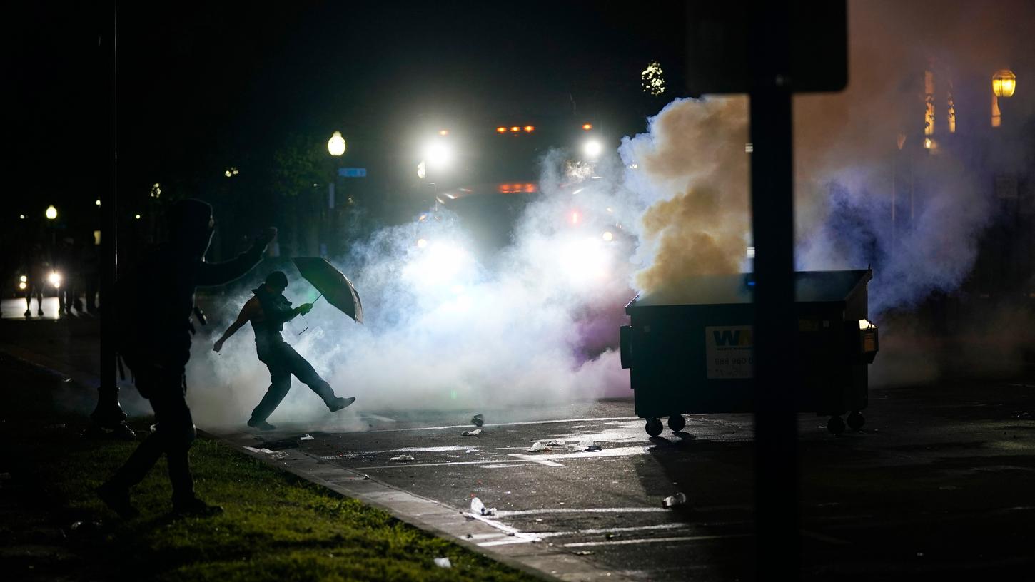 Ein Demonstrant tritt während eines Protests in Kenosha (Wisconsin, USA) einen Rauchkanister über die Straße. Mehrere Schüsse in den Rücken des schwarzen Amerikaners Jacob Blake bei einem Polizeieinsatz im US-Bundesstaat Wisconsin haben Entsetzen und Proteste ausgelöst