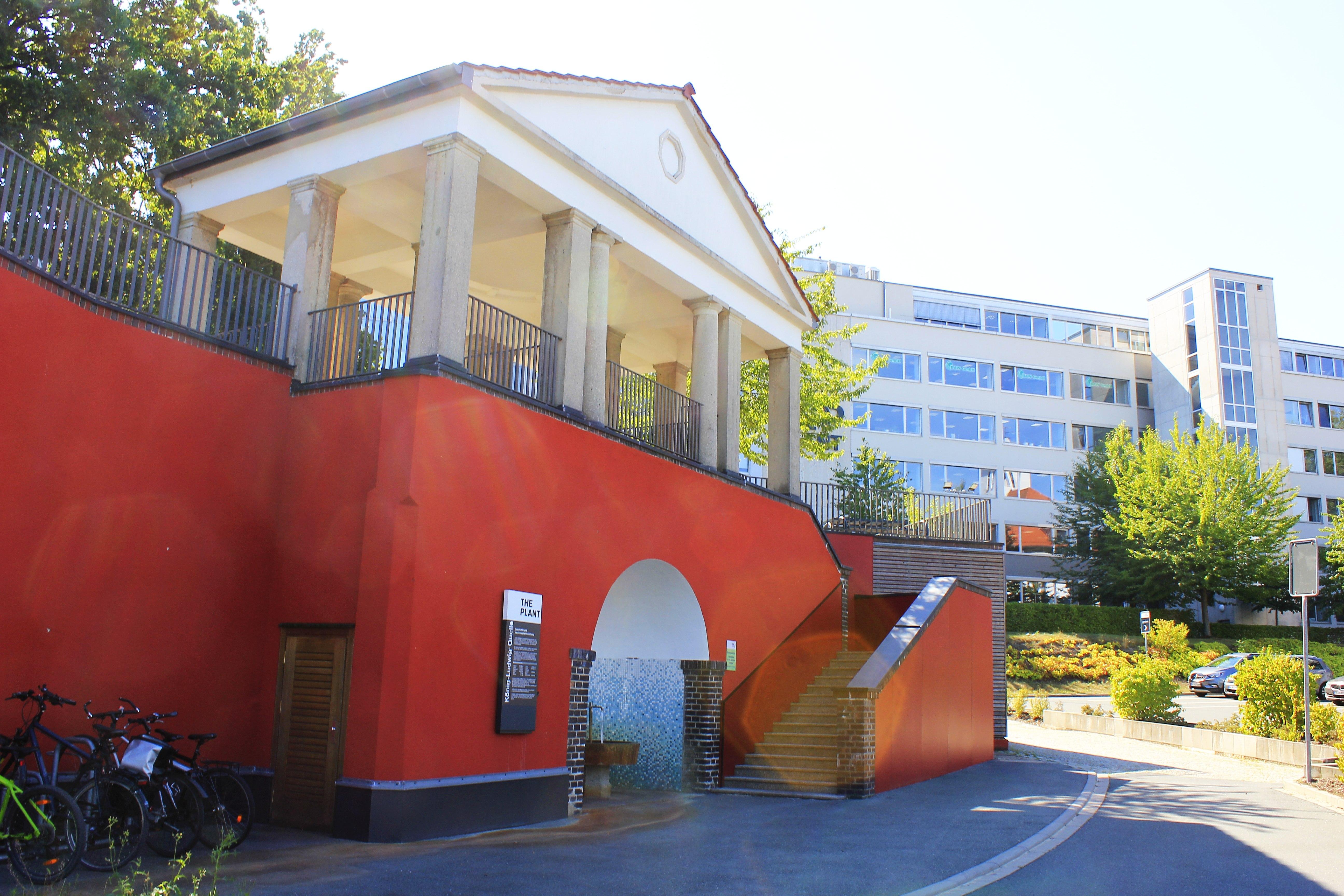 Die König-Ludwig-Quelle ist aber immer noch da. Unter einem neuklassizistischem Aussichtspavillon mit Freitreppen schießt das aus 400 Metern Tiefe kommende Heilwasser aus drei Rohren ins Becken des Trinkbrunnens. Das Wasser kann in kleinen Mengen getrunken werden, offiziell aber nur nach Verordnung eines Arztes.