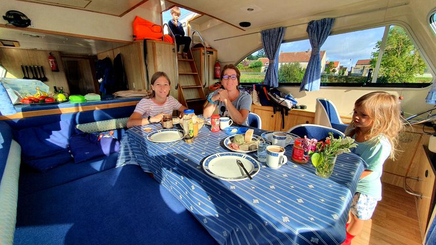 Familienfrühstück im Inneren des Hausbootes Calypso vom Vermieter Le Boat. 
