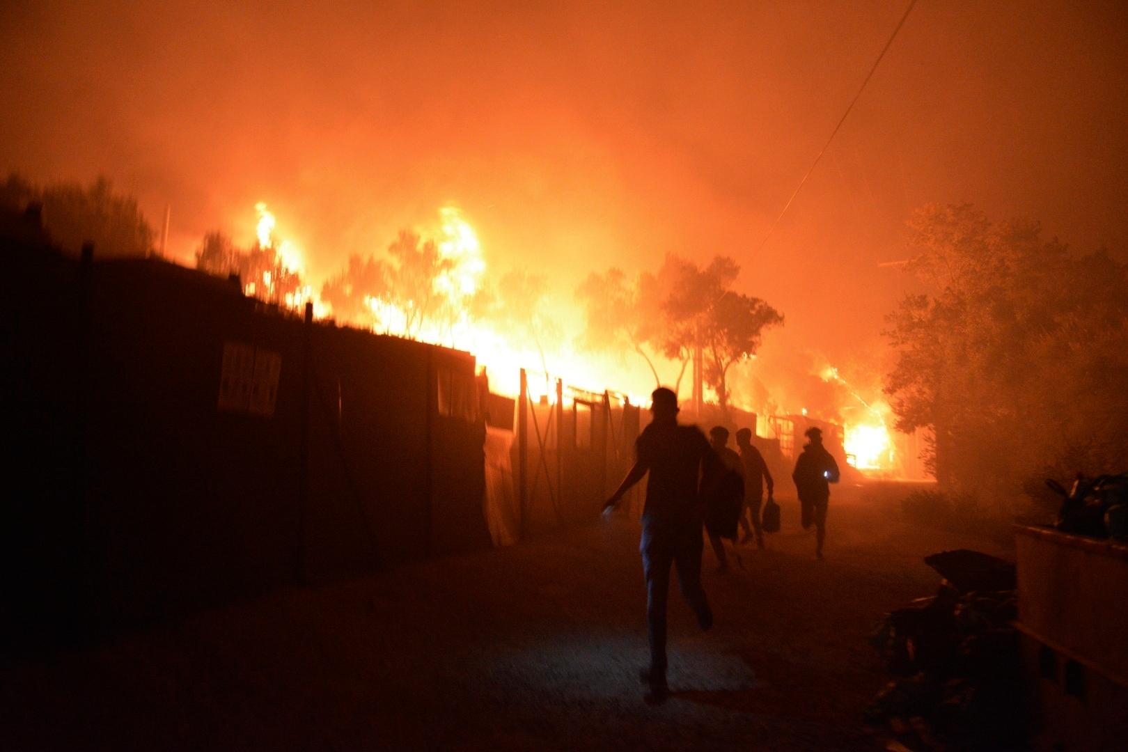 Geflüchtete sind auf der Flucht vor den riesigen Flammen. Das Feuer brach am 9. Sepember im Flüchtlingslager Moria auf der griechischen Insel Lesbos aus.