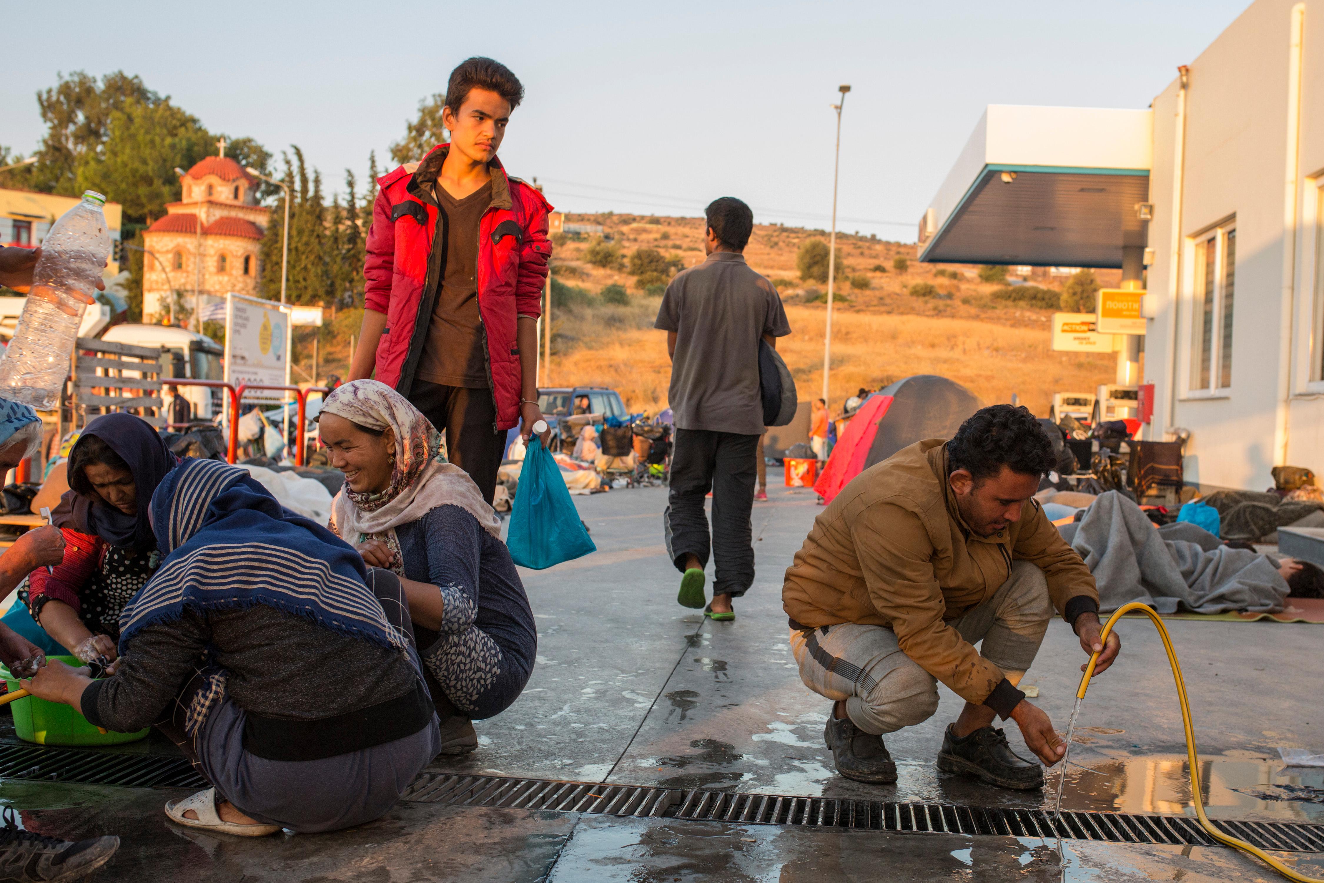 Menschen waschen sich an einer Tankstelle in der Nähe des ausgebrannten Flüchtlingslagers Moria. 