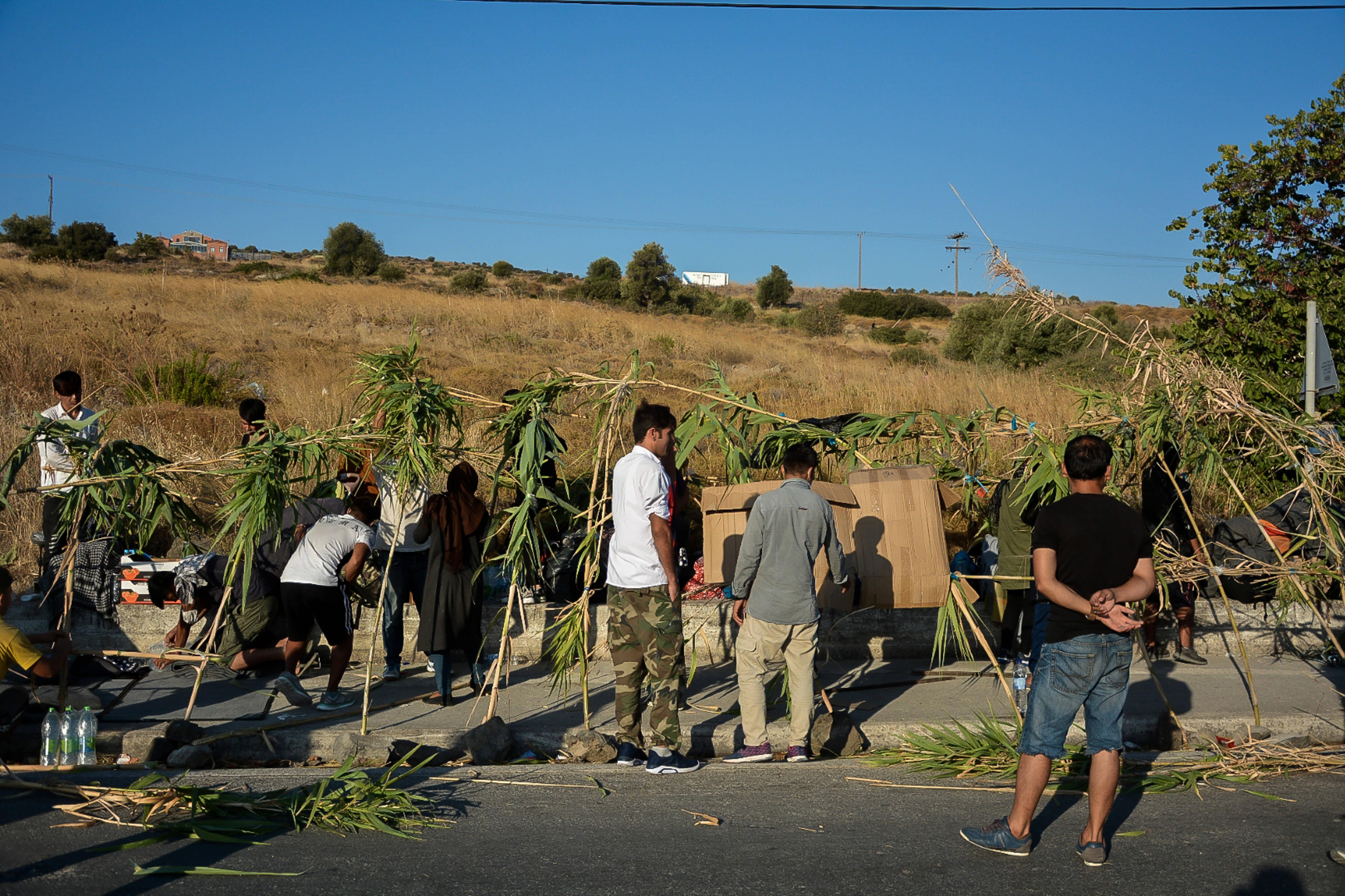 Geflüchtete bauen am Freitag, zwei Tage nach dem verheerenden Brand, mit Schilfrohr provisorische Lager und Schutz gegen die Hitze außerhalb des zerstörten Flüchtlingcamps.