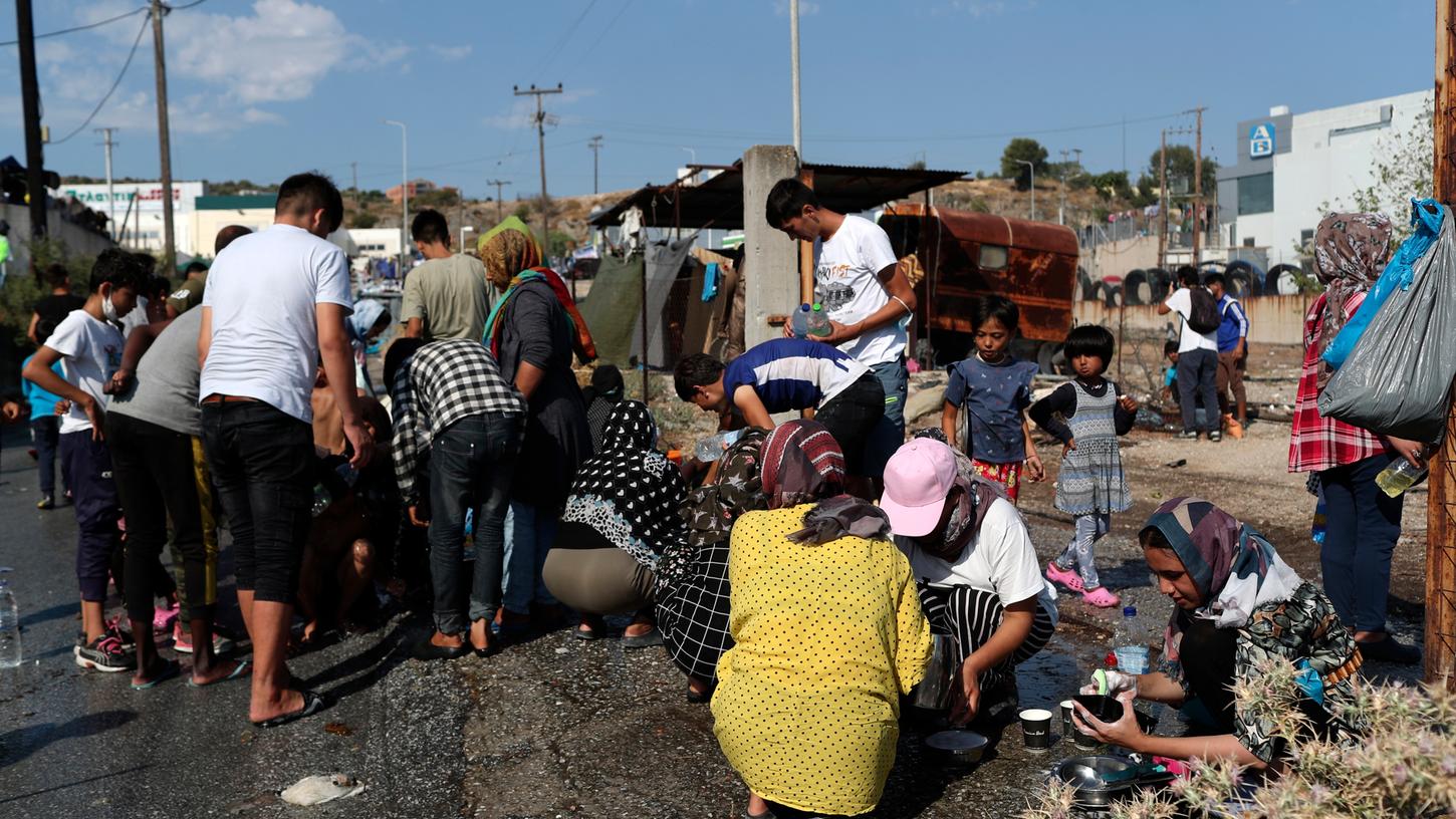 Migranten kochen und bereiten Essen am Straßenrand zu. Mehrere Tausend Geflüchtete sind in Folge der Brände in dem überfüllten Flüchtlingslager Moria obdachlos geworden