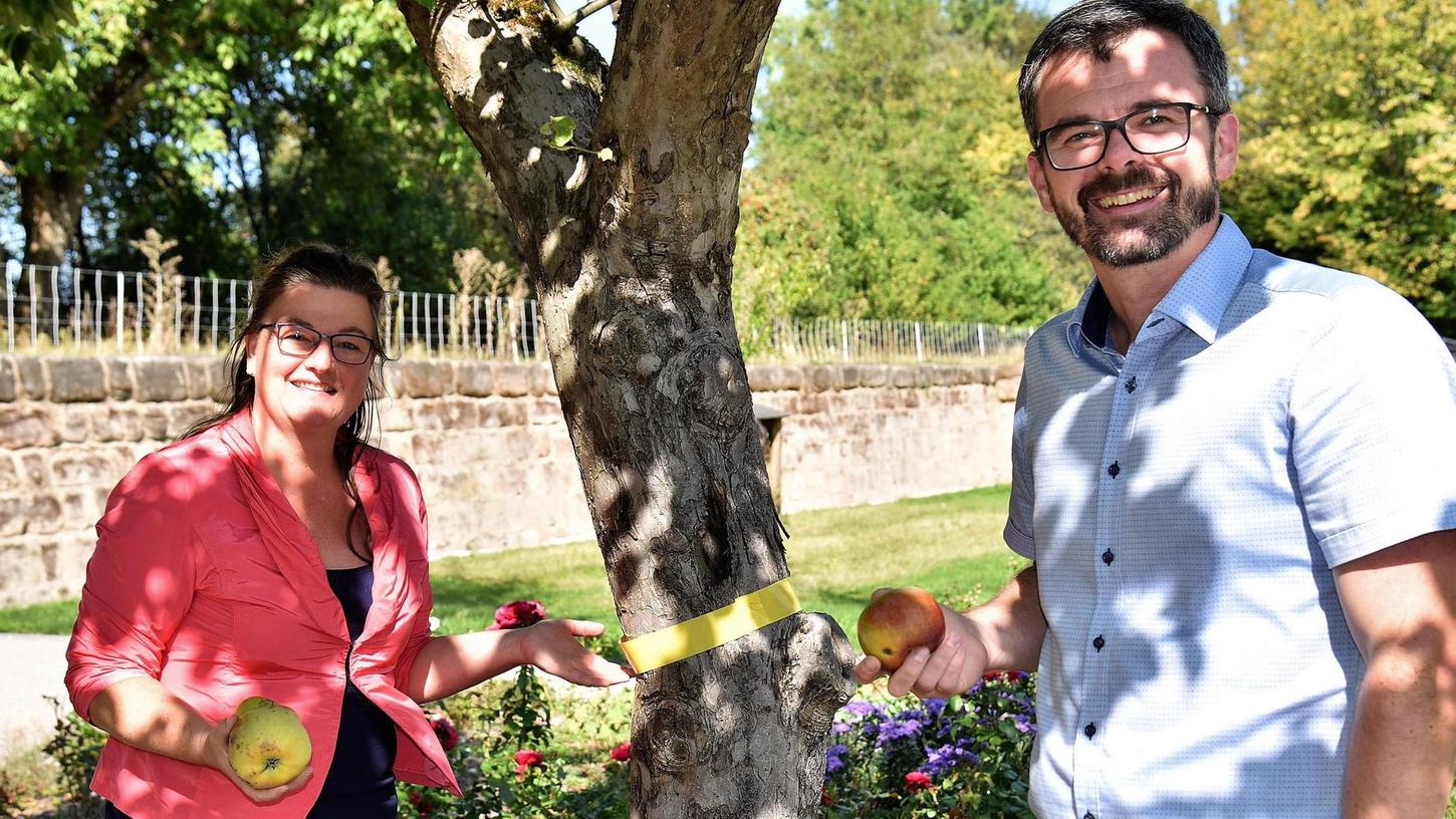 Markträtin Stephanie Jaspers und Bürgermeister Michael Langner weisen auf die gelben Bänder an Obstbäumen hin: Hier ist das gesunde Naschen ausdrücklich erlaubt.