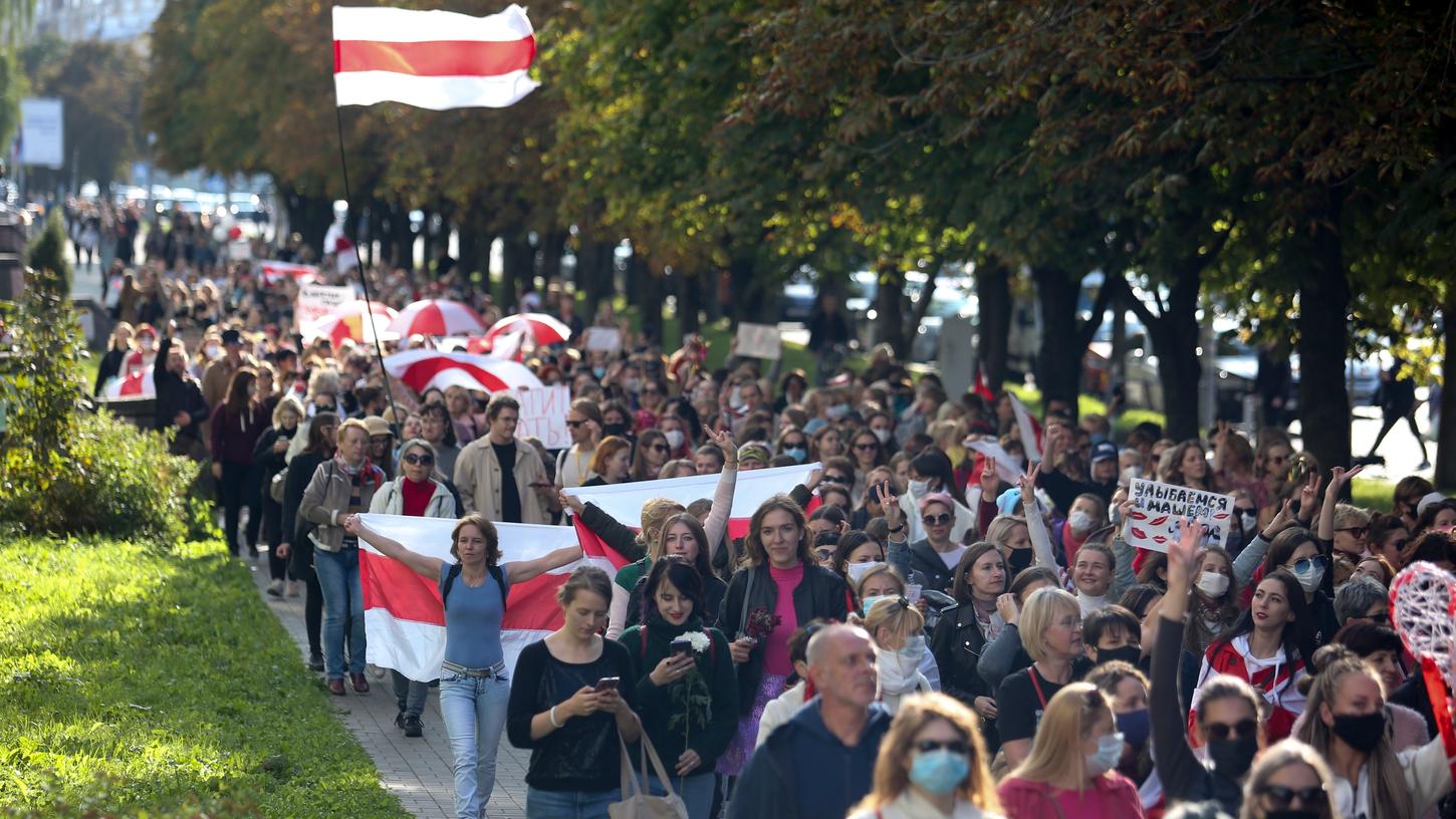 Frauen mit alten belarussischen Nationalflaggen bei der Demonstration am Samstag.