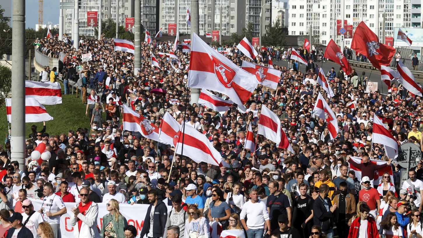 Minsk: Demonstranten halten historische belarussische Flaggen und nehmen an einem Protest der Opposition teil. 