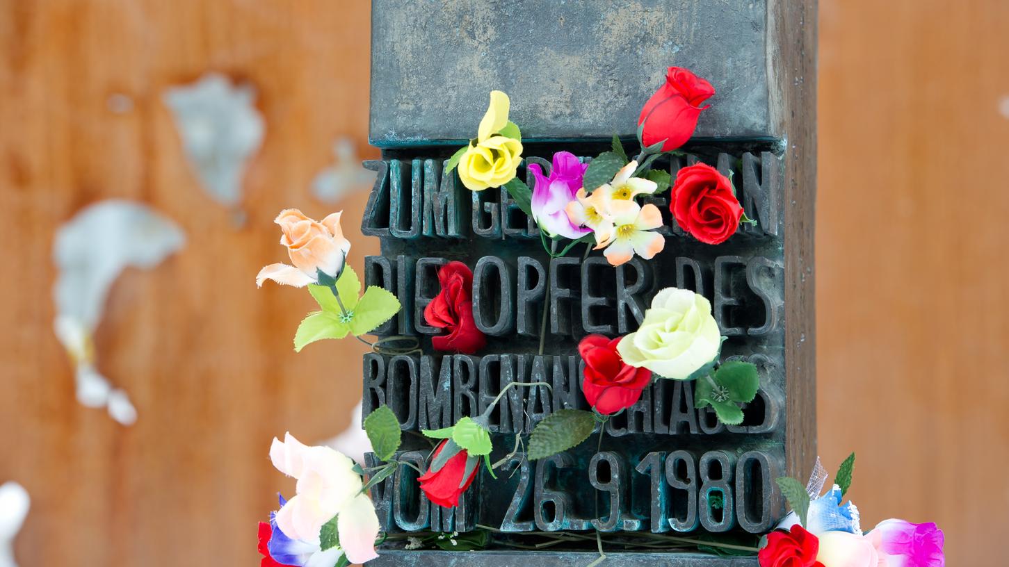 Blumen stecken an einem Denkmal am Haupteingang der Theresienwiese, das an die Opfer des Attentats auf das Oktoberfest erinnert.