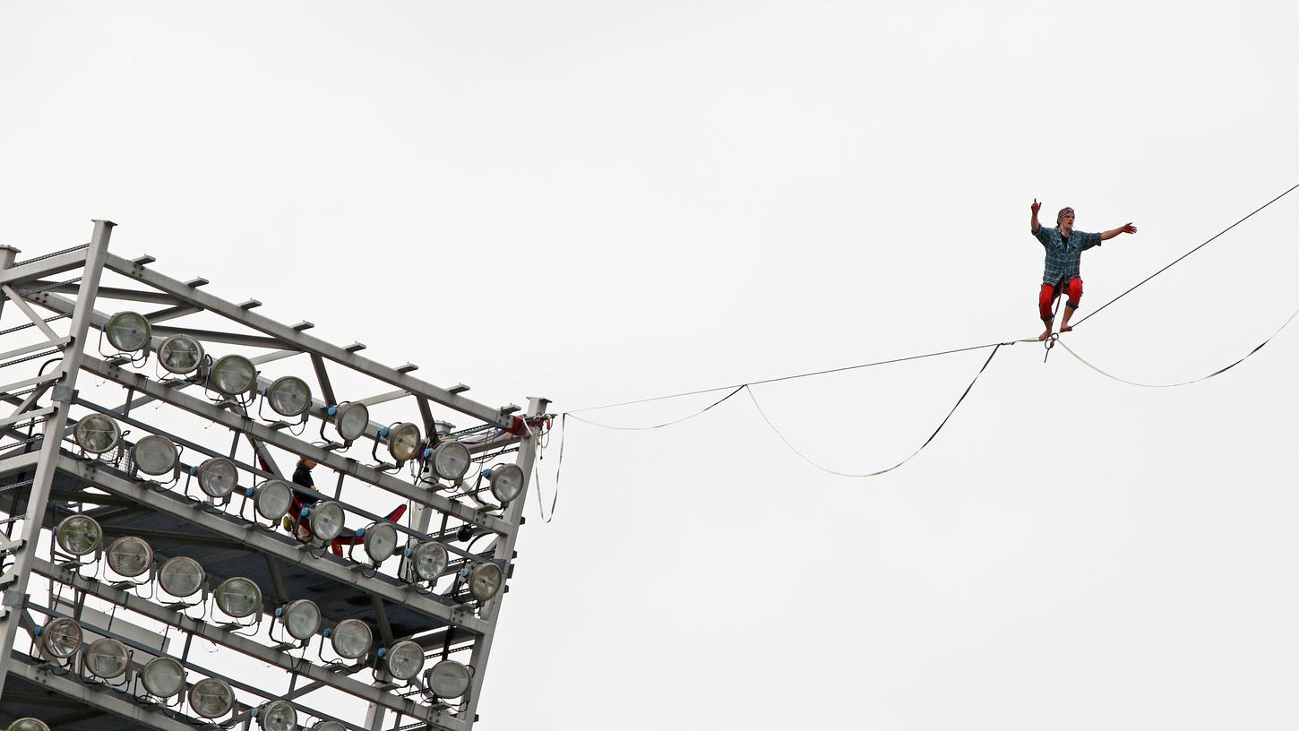 Eine Slackline-Gruppe balanciert 230 Meter von Flutlichtmast zu Flutlichtmast.