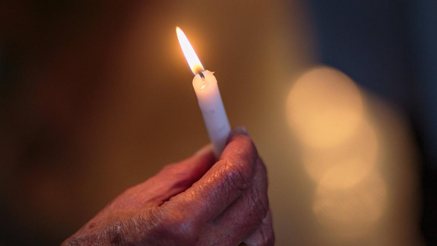 Eine Kerze zum Gedenken: Das Abschiednehmen von einem geliebten Menschen fällt schwer. Letzte-Hilfe-Kurse helfen beim Umgang mit Trauer und Tod.