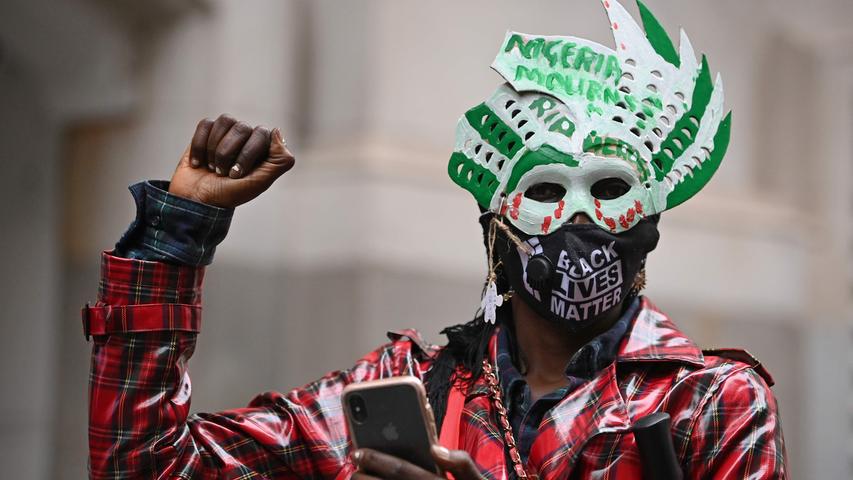 Mit erhobener Faust und Maske: Auch in London wird gegen die Polizeigewalt in Nigeria protestiert. Die Regierung in dem afrikanischen Land gibt inzwischen zu, dass in dieser Woche dutzende Demonstranten getötet wurden.