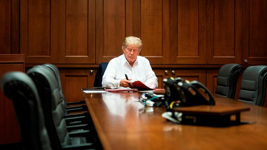 Kurz nachdem er wegen seiner Infektion mit dem Corona-Virus in einem Militärkrankenhaus behandelt wurde, präsentiert sich Trump mit Akten im Konferenzraum.